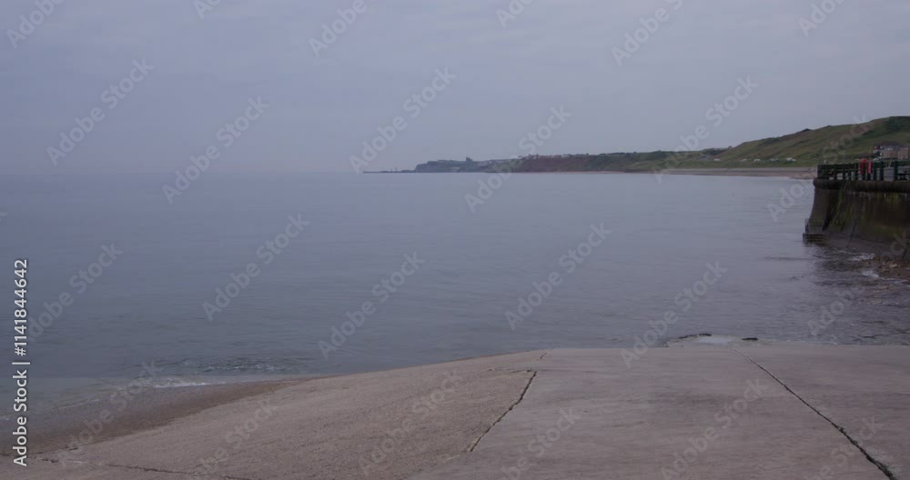 Wide shot looking south of sandsend wyke bay with boat slipway in foreground at sandsend, whitby