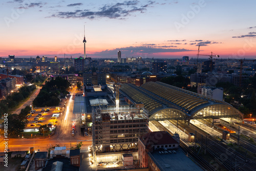 Ausblick auf Berlin mit der untergehenden Sonne am Horizont und der Berliner Fernsehturm Alex und dem Ostbahnhof.  photo