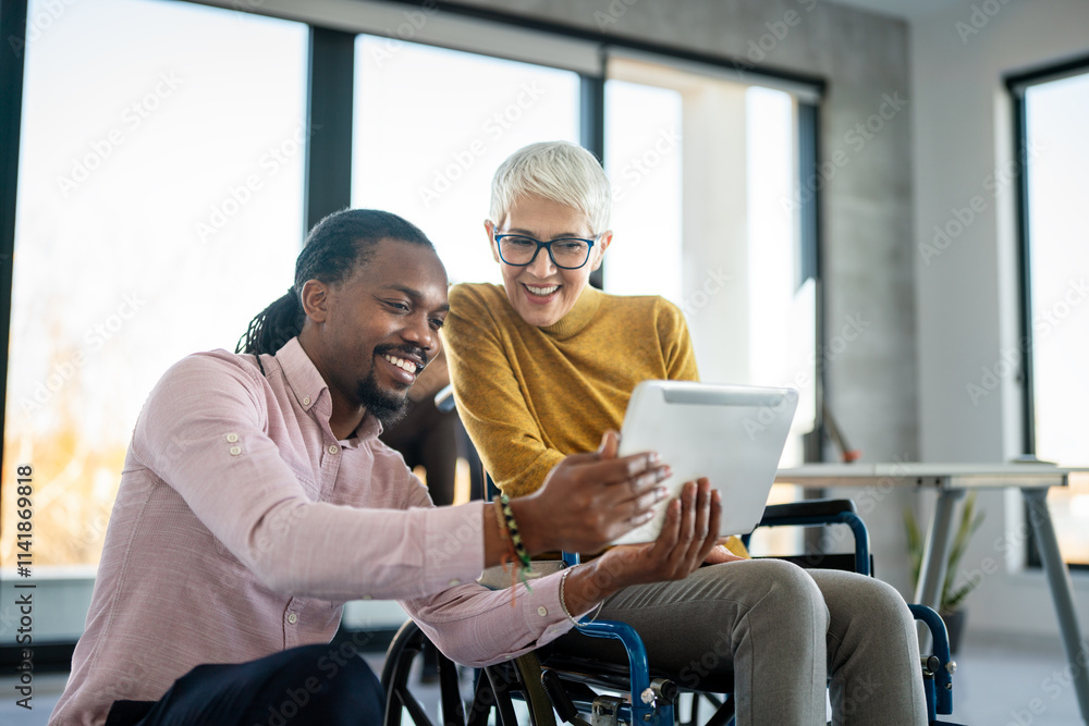 © NDABCREATIVITY - Disabled woman in wheelchair looking at computer, discussing startup project with interracial team © NDABCREATIVITY - Disabled woman in wheelchair looking at computer, discussing startup project with interracial team