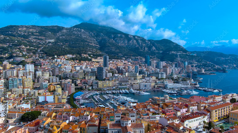 Stunning aerial shot of Monaco's vibrant harbor, luxurious yachts, colorful buildings, and dramatic mountain backdrop. Ideal for travel, luxury living, and scenic coastal photography themes. Stunning aerial shot of Monaco's vibrant harbor, luxurious yachts, colorful buildings, and dramatic mountain backdrop. Ideal for travel, luxury living, and scenic coastal photography themes.