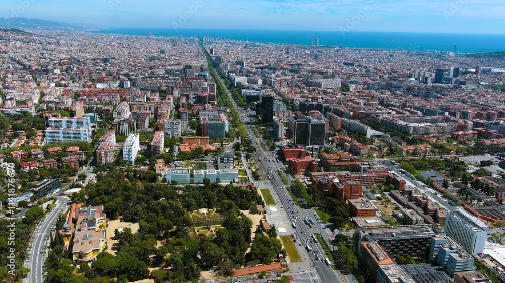 Obraz premium Stunning aerial view of Barcelona showcasing its iconic urban landscape, green spaces, and Mediterranean coastline. Perfect for travel, architecture, and city lifestyle visuals.