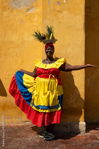 Woman Wearing A Colorful Traditional Colombian Dress Balancing Fruits On Her Head
