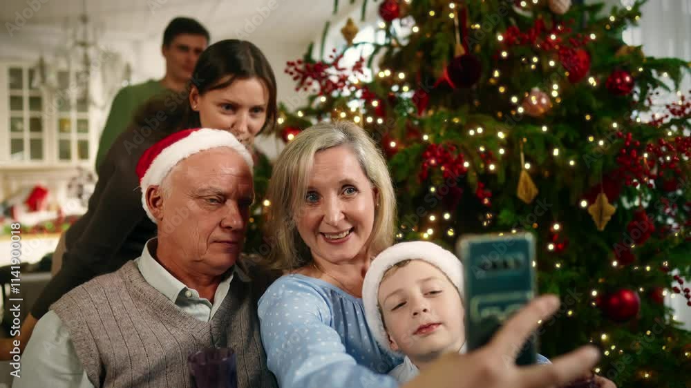 Happy family taking pictures by smartphone in Christmas eve, celebrate together. Grandparents, parents and little boy spending time joint in winter vacation, happy childhood moments, portrait shot Happy family taking pictures by smartphone in Christmas eve, celebrate together. Grandparents, parents and little boy spending time joint in winter vacation, happy childhood moments, portrait shot