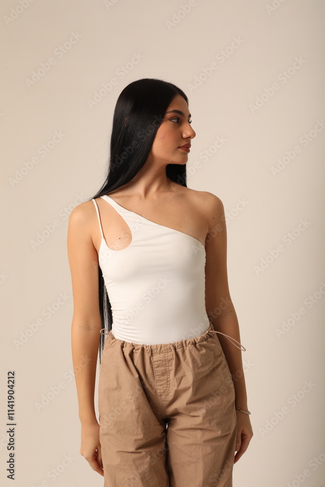 Obraz premium Vertical headshot of beautiful young woman with long dark hair looking away. Mock-up.