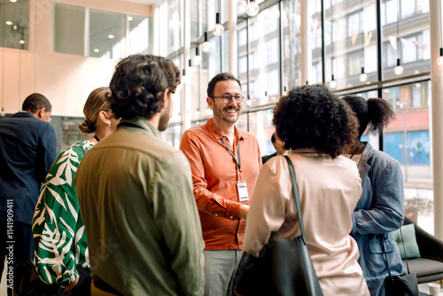 Smiling male and female business professionals greeting each other during networking event at convention center photo