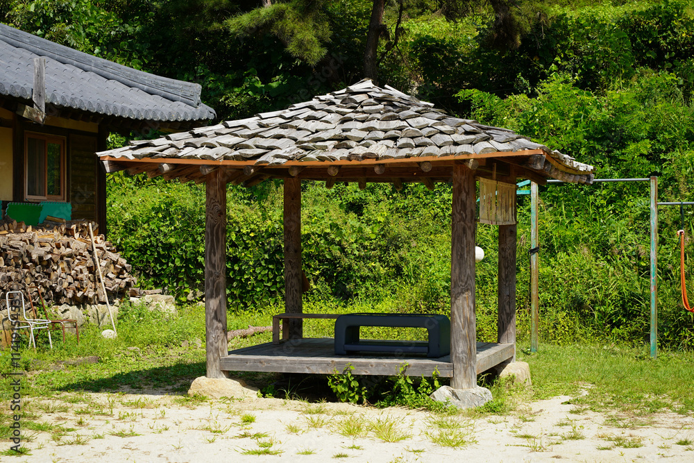 A wooden pavilion structure offering a peaceful resting spot, blending harmoniously with its natural surroundings. A wooden pavilion structure offering a peaceful resting spot, blending harmoniously with its natural surroundings.