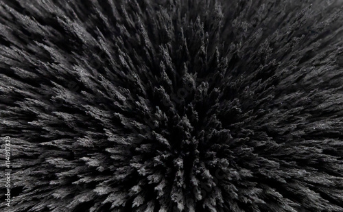 Reaction of iron dust to a magnetic field. Iron filings spikes. Neodymium magnet. Isolated on a black background.