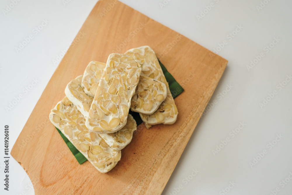 Raw tempeh that has been cut on a cutting board Raw tempeh that has been cut on a cutting board