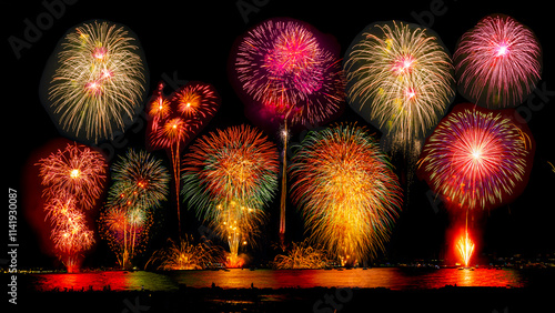 Real fireworks background. Real abstract celebration fireworks light show blur gold shining light night sky. Fireworks glowing, beautiful, explosion fireworks. New year's day fireworks in the sea.