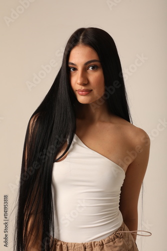 Vertical headshot of beautiful young woman with long dark hair looking at the camera. Mock-up.