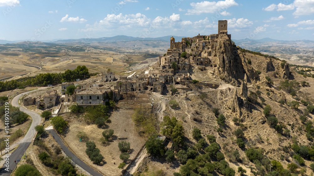 Fototapeta premium Aerial view of Craco, a ghost town in the province of Matera, Basilicata, Italy. The historic center was depopulated due to a landslide and has become a tourist destination.