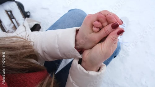 A young woman warms her hands in the cold by rubbing. Snow, winter, cold