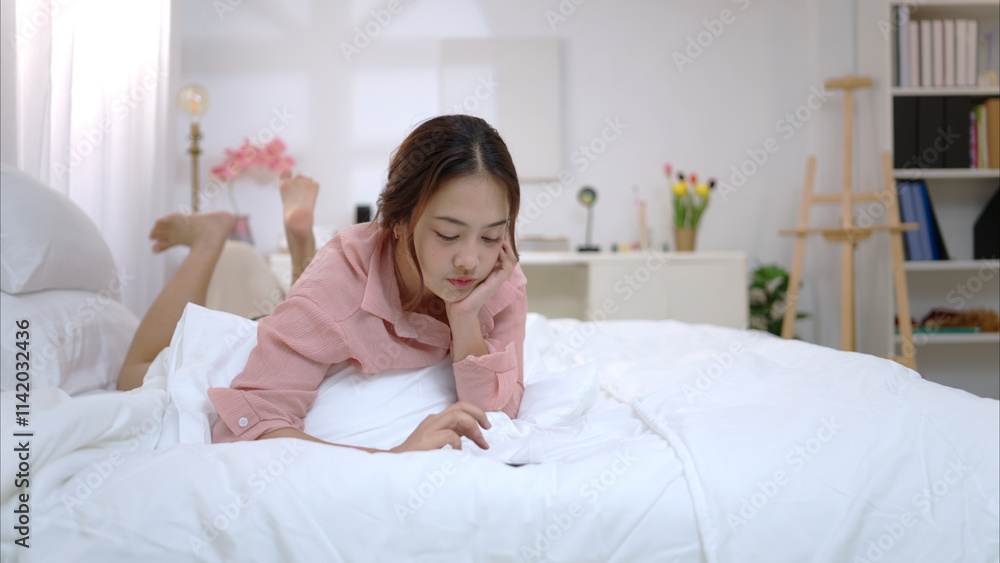 Asian young woman relaxing before bedtime on the bed in the bedroom Asian young woman relaxing before bedtime on the bed in the bedroom