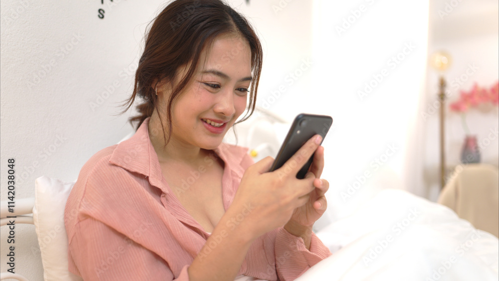 Asian young woman relaxing before bedtime on the bed in the bedroom Asian young woman relaxing before bedtime on the bed in the bedroom