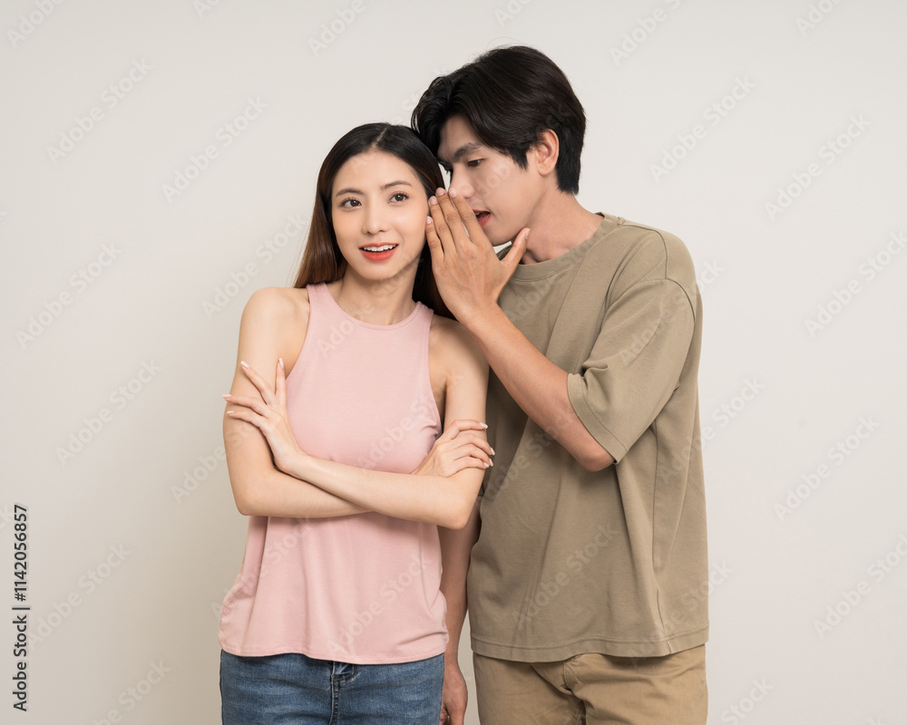 Whispering some secret gossip.Happy asian couple attractive in various action gesture standing on isolated white background. Cheerful Smiling young man and woman whispering some secret gossip. Whispering some secret gossip.Happy asian couple attractive in various action gesture standing on isolated white background. Cheerful Smiling young man and woman whispering some secret gossip.