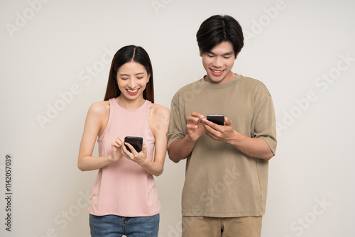 Happy asian couple attractive in various action gesture using smartphone standing on isolated white background. Cheerful Smiling young man and woman holding cell phone photo