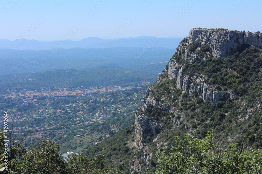Naklejka premium Hauteur de la côte d'Azur, Provence, massif montagneux du Baou de la Gaude en randonnée au soleil de près avec village pittoresque en fond