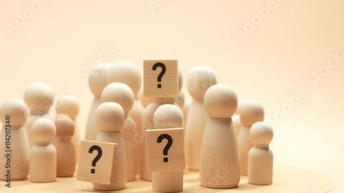Rotating A group of wooden people holding a question mark. Concept of curiosity and uncertainty as people try to find an answer to the question of who they are.
