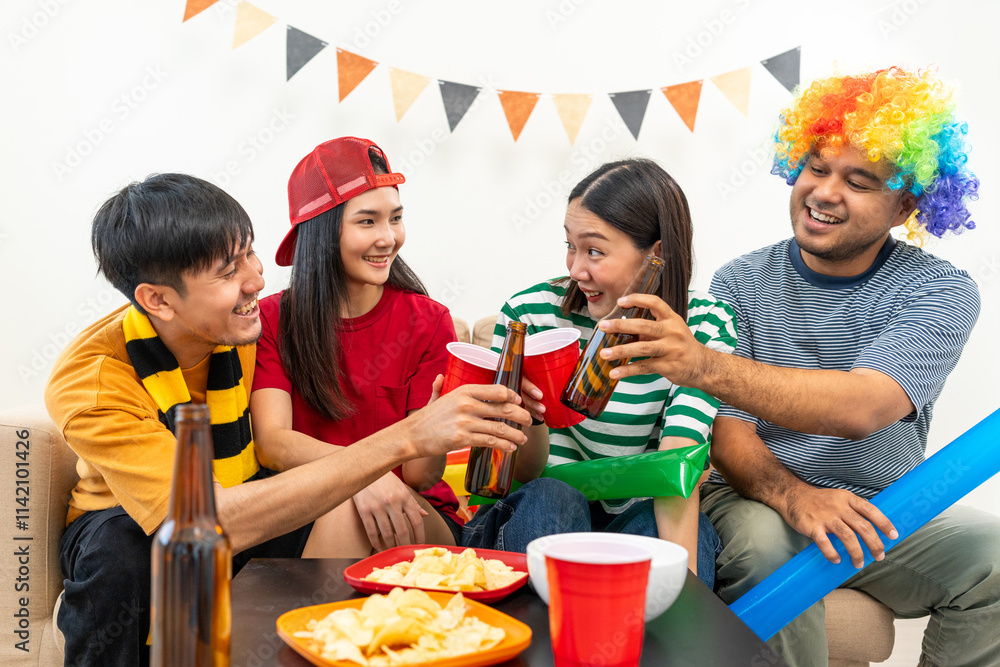 Obraz premium Group of asian friends man and woman watching cheering football match on TV at home. Eating snack and drinking beer. Sport fans people shouting and celebrating sport team victory match.