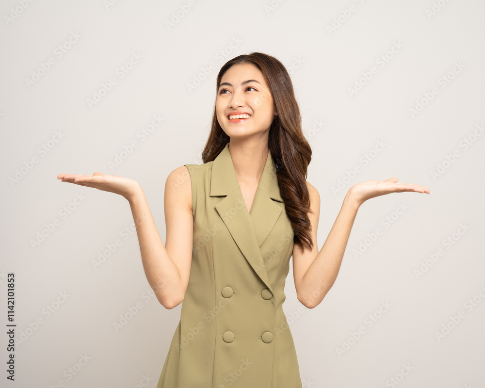 Beautiful smiling happy young asian woman in green shirt pointing finger. Charming female lady open hands palm up holding something on isolated white background. Asian woman looking blank space. Beautiful smiling happy young asian woman in green shirt pointing finger. Charming female lady open hands palm up holding something on isolated white background. Asian woman looking blank space.
