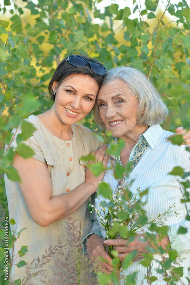 An elderly woman with her daughter in the park in summer