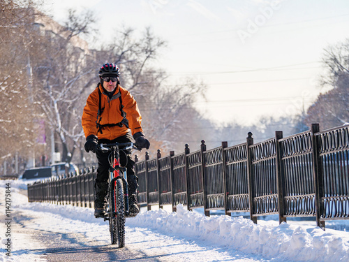 An exciting winter adventure in the city by bicycle. A man rides a bicycle on a snowy street