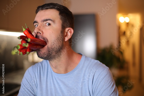 Man with a mouth full of spicy jalapenos 