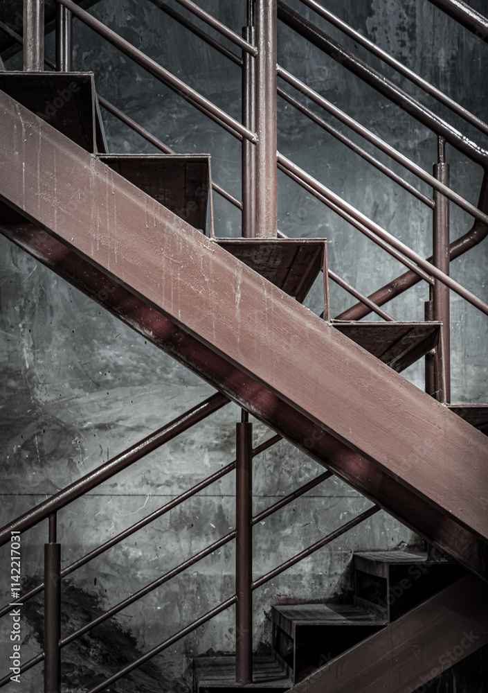 Vertical view of Old Steel ladder with handrails with concrete wall in the background. Side view of Metal steps, Dark tone, Copy space, Selective Focus.