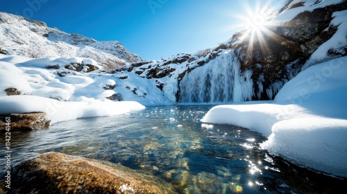 A picturesque snow-covered mountain scene with a sunlit stream reflecting the clear blue sky, creating a harmonious and visually stunning natural image. photo