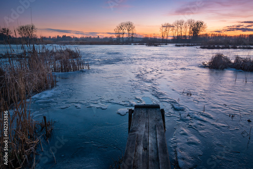 Wallpaper Mural A small wooden bridge in front of a frozen lake during sunset, Stankow, Lubelskie, Poland Torontodigital.ca
