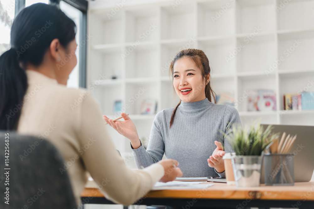 Two women having friendly discussion in modern office Two women having friendly discussion in modern office