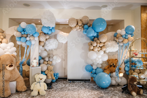 Arch with bears decoration brown, blue balloons. Celebration baptism. Trendy winter decor. Delicious reception. Birthday Cake for boy on a background candy bar. Table with sweets, candies, dessert.