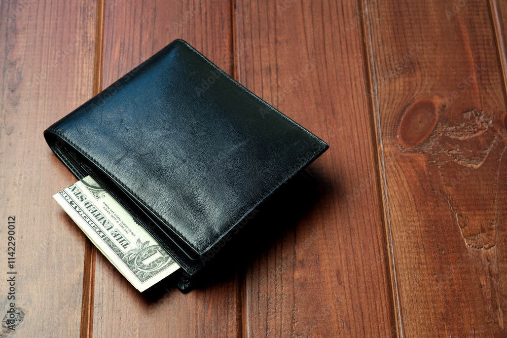 Wallet on wooden table with cash folded neatly inside it