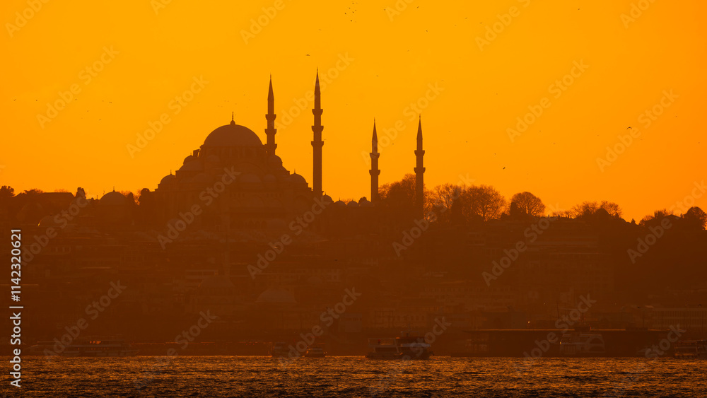 Silhouette of Suleymaniye Mosque at sunset. Golden sky and clouds.