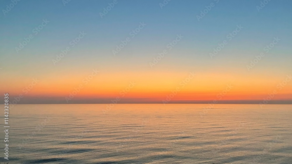 A breathtaking scene of the sun setting over the sea, casting vibrant hues of orange, pink, and blue across the sky while its reflection shimmers on the calm water A breathtaking scene of the sun setting over the sea, casting vibrant hues of orange, pink, and blue across the sky while its reflection shimmers on the calm water