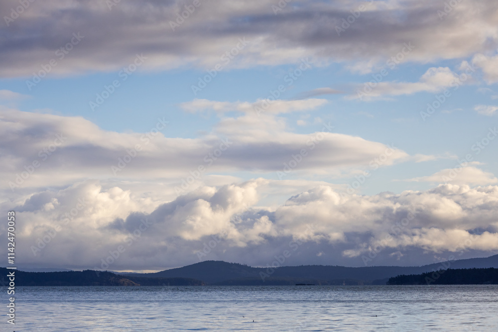 Scenic Coastal View With Cloudy Sky and Distant Forested Islands Scenic Coastal View With Cloudy Sky and Distant Forested Islands