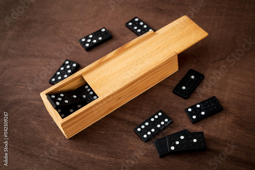 box of domino tiles on a wooden table