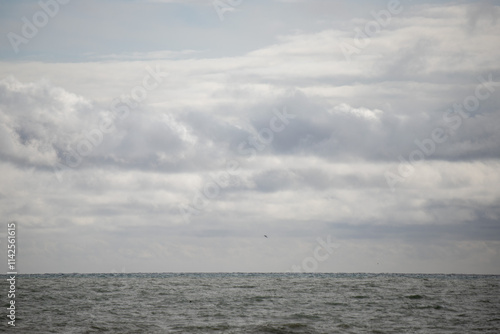 Blue sea and blue sky with white clouds. Seascape.