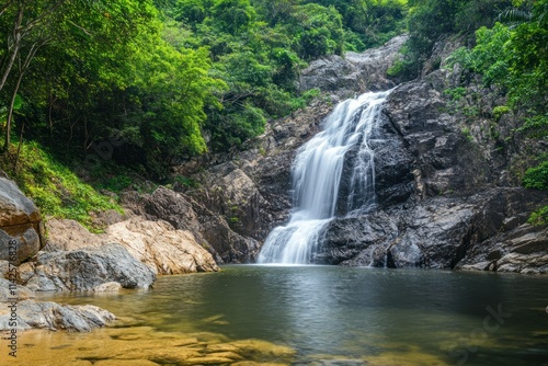 Waterfall cascading down lush green forest surrounded by tropical vegetation