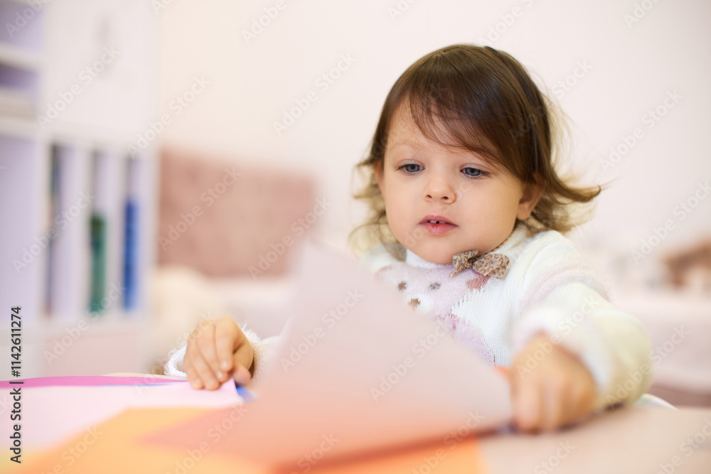 little child girl holding multi-color paper while sitting by table at home, Children creativity little child girl holding multi-color paper while sitting by table at home, Children creativity