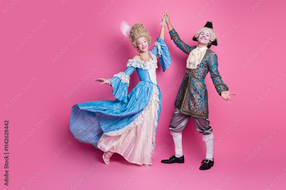 Fototapeta premium A couple in elegant historical costumes dance against a lively pink background, representing a vibrant celebration of aristocratic fashion