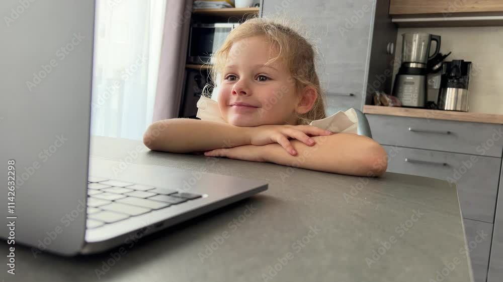 Little girl watching cartoons on laptops at home and laughing Little girl watching cartoons on laptops at home and laughing