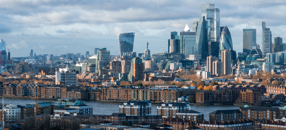 Obraz premium Aerial view of London's skyline featuring the Walkie Talkie, the Gherkin, and the Shard. The River Thames flows amidst modern and historic architecture.