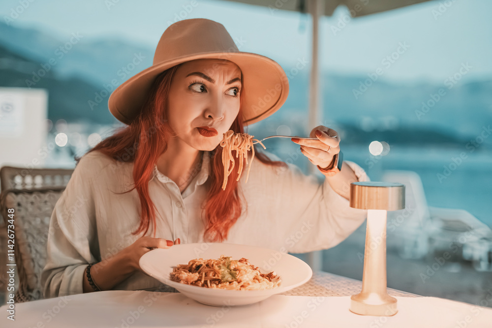 Woman disgusted by her spaghetti while dining in restaurant by the sea