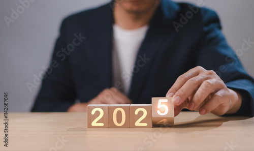 Happy New Year, Business Goals and Visions for 2025, Starting a Business, Performance Goals for Success, Businessman's hand holding 2024 to 2025 cube wood Showing Annual Business Strategy
