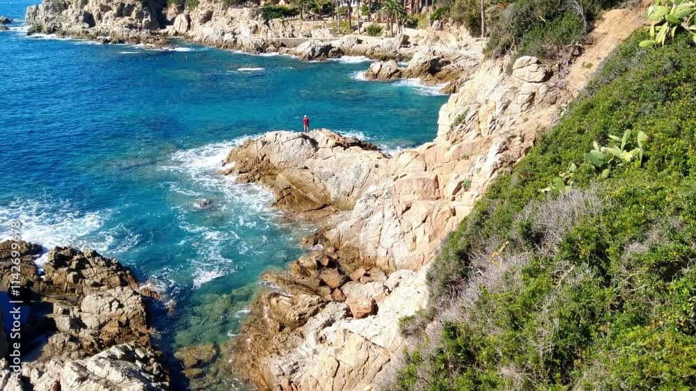 Coastal Rocky Shoreline with Turquoise Waters and Solitary Figure Coastal Rocky Shoreline with Turquoise Waters and Solitary Figure