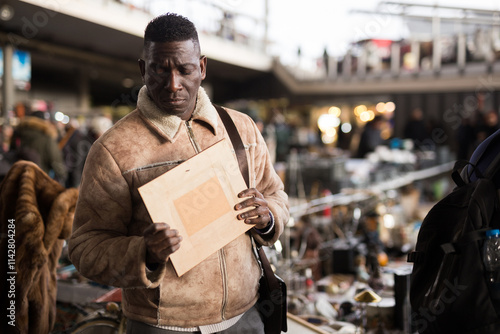  Man chooses antiques at a flea market photo