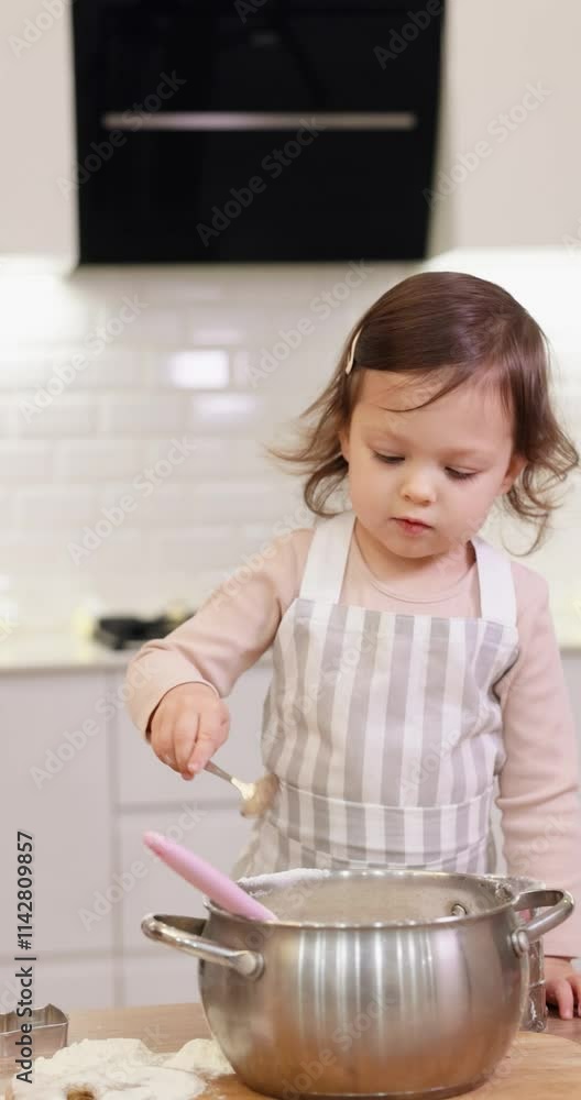 cute little child girl in apron sifting flour for baking in modern kitchen cute little child girl in apron sifting flour for baking in modern kitchen