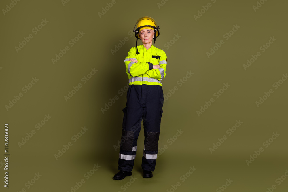 Portrait of a mature female professional in a bright uniform with a khaki background, highlighting her role in construction and safety Portrait of a mature female professional in a bright uniform with a khaki background, highlighting her role in construction and safety
