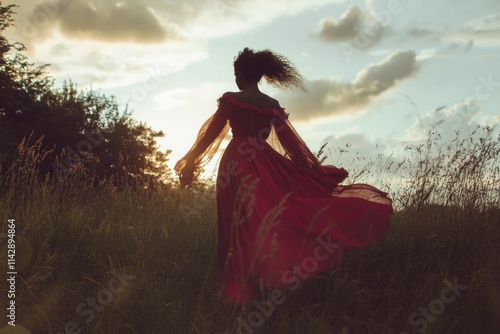 A woman walks through a green field wearing a bright red dress, a sunny day with no people around